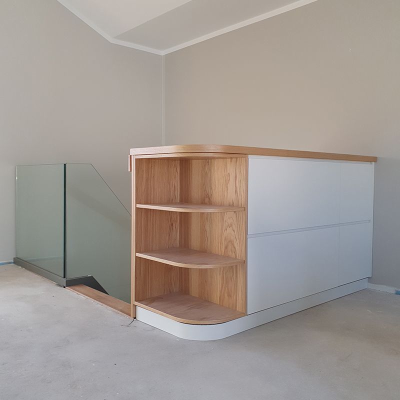 Eine Treppe mit Glasgeländer und Holzregal