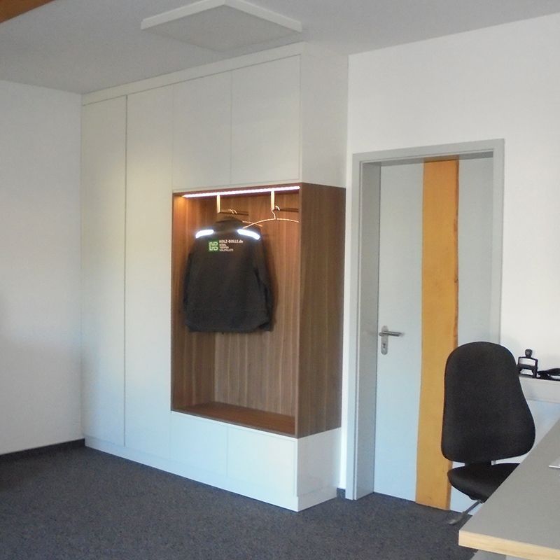 Ein Zimmer mit einem Stuhl und einer Jacke an der Wand