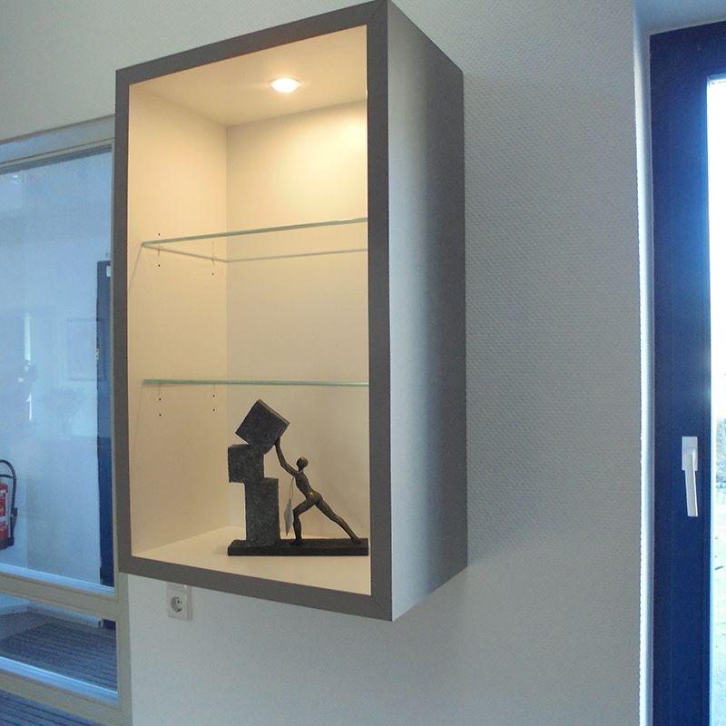 Ein Regal mit einer Statue eines Mannes, der einen Würfel darauf hält