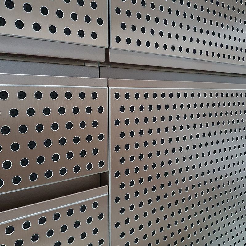 Eine Nahaufnahme einer Metallwand mit Löchern darin