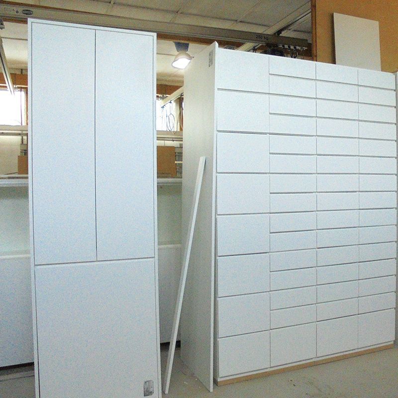 Eine Reihe weißer Schränke mit vielen Schubladen