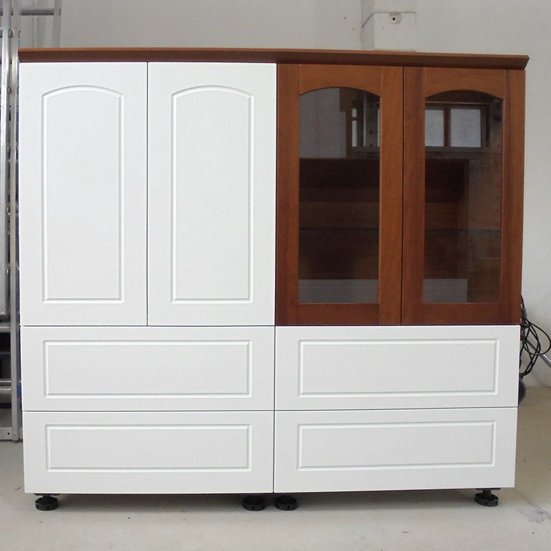 Ein weißer Schrank mit Holztüren und Schubladen