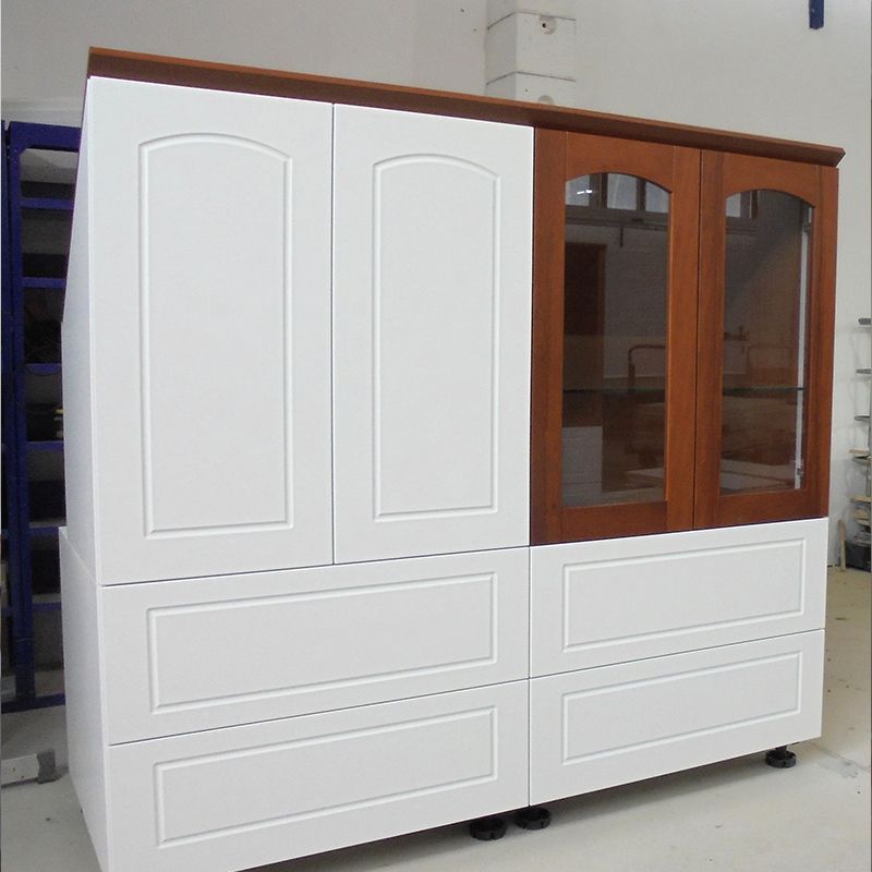 Ein großer weißer Schrank mit Holztüren und Schubladen