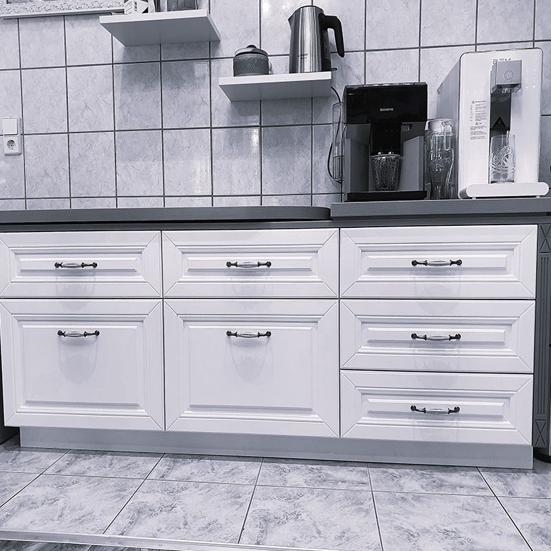 Ein Schwarzweißfoto einer Küche mit weißen Schränken