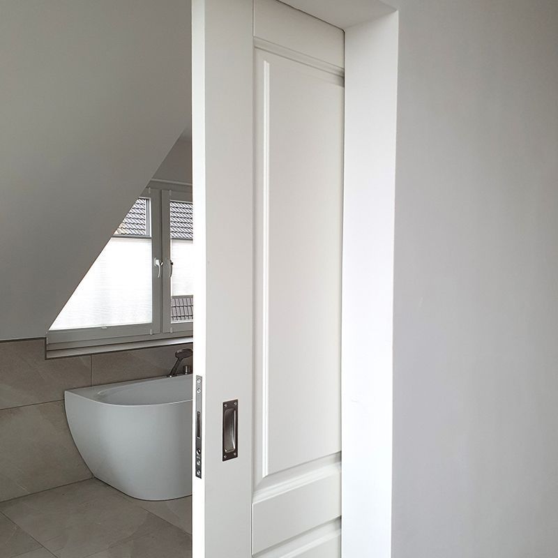 Eine weiße Tür öffnet sich zu einem Badezimmer mit Badewanne.