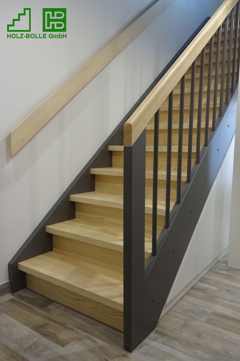 Eine Holztreppe mit schwarzem Geländer und einem Schild mit der Aufschrift „Holz-soll-dreht“