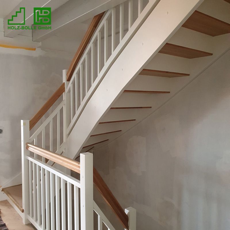 Eine weiße Treppe mit einem Holzgeländer und einem Schild mit der Aufschrift „Holzbau GmbH“