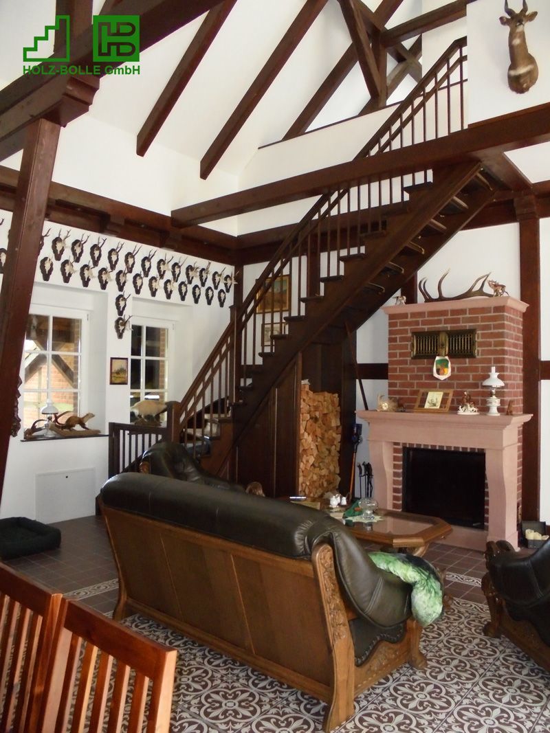 Ein Wohnzimmer mit einer Couch, einem Kamin und einer Treppe