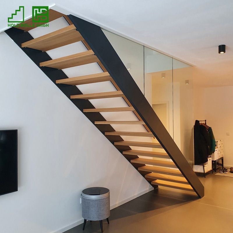 Eine Holztreppe mit Glasgeländer in einem Wohnzimmer.