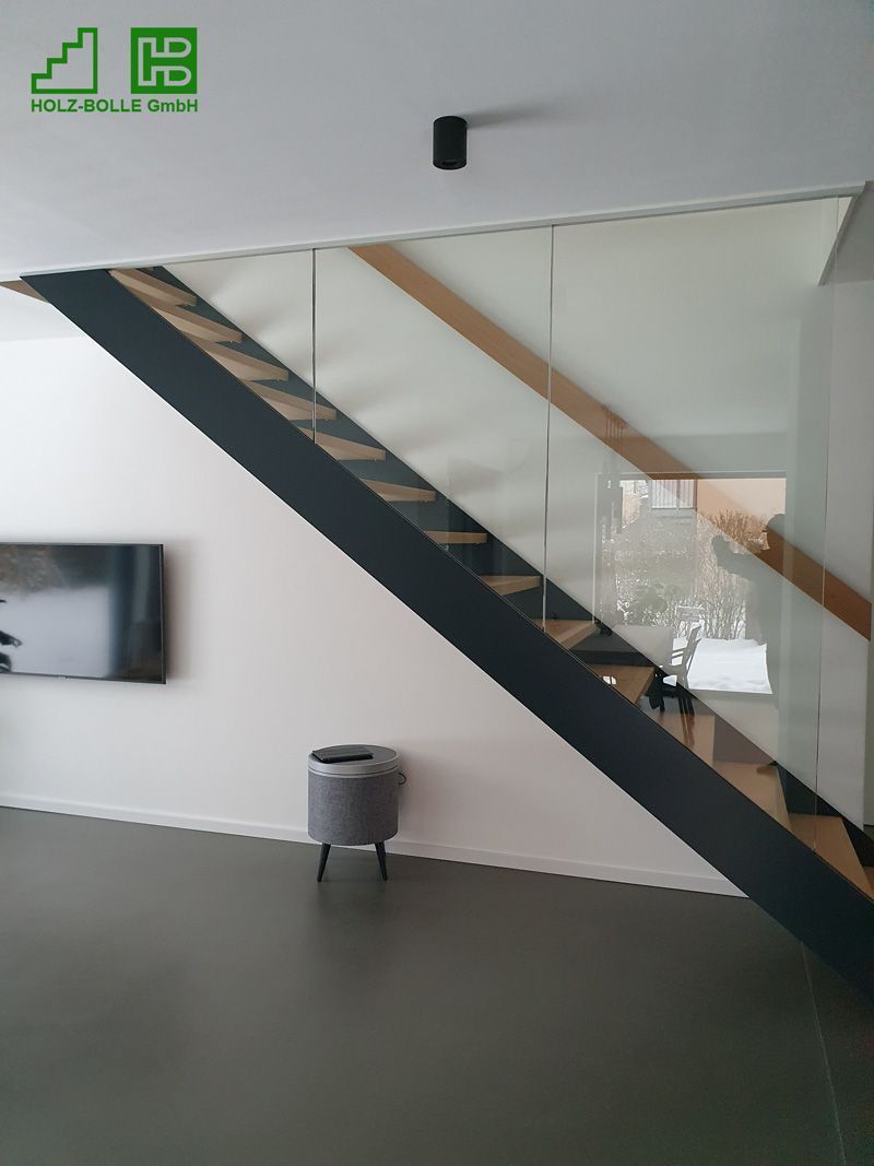 Eine Treppe mit Glasgeländer in einem Wohnzimmer