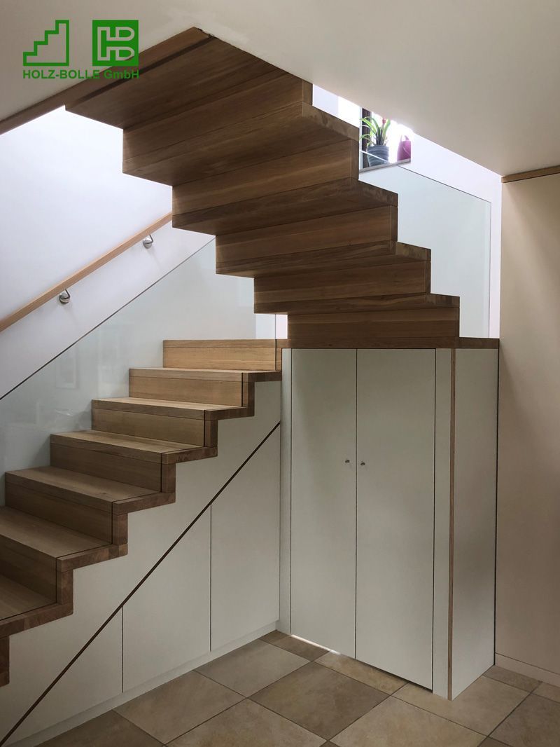 Eine Holztreppe mit weißen Schränken darunter