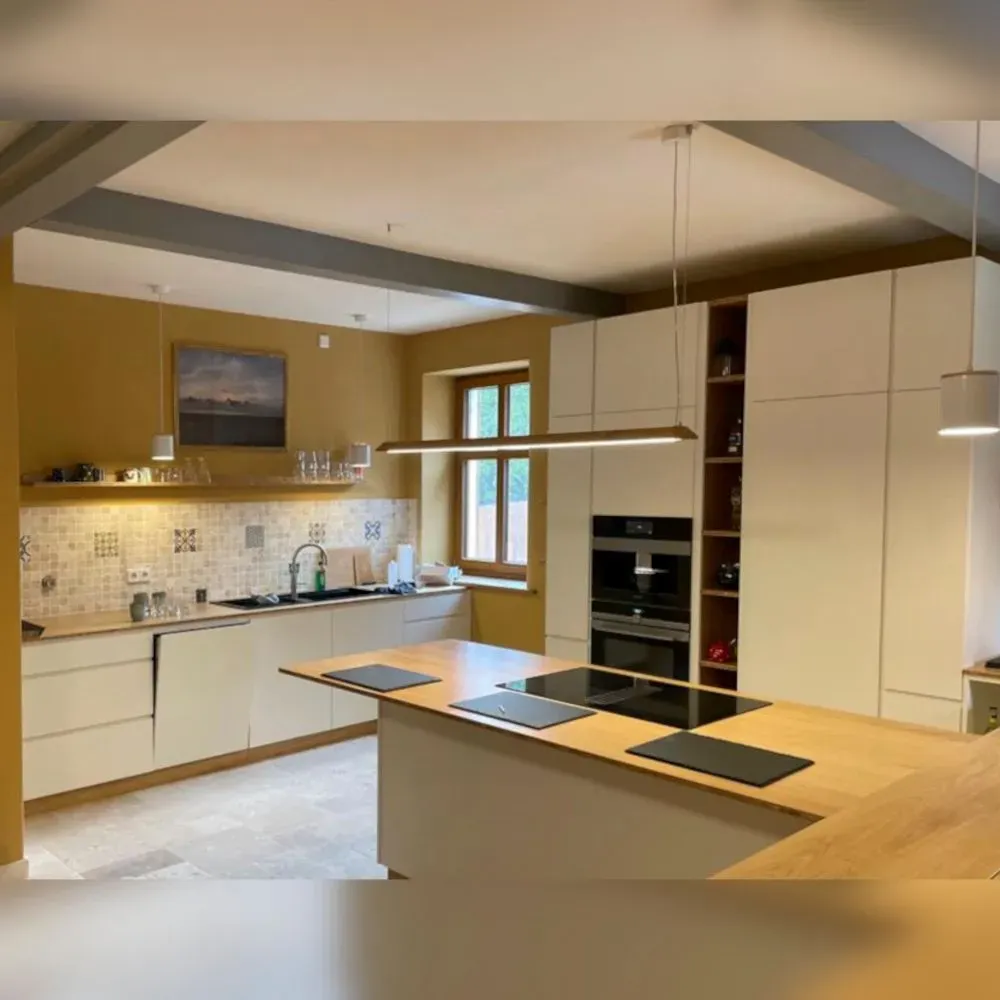 Eine Küche mit weißen Schränken und Holzarbeitsplatten