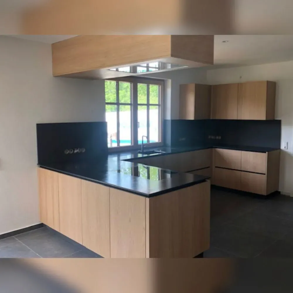 Eine Küche mit Holzschränken und einer schwarzen Arbeitsplatte