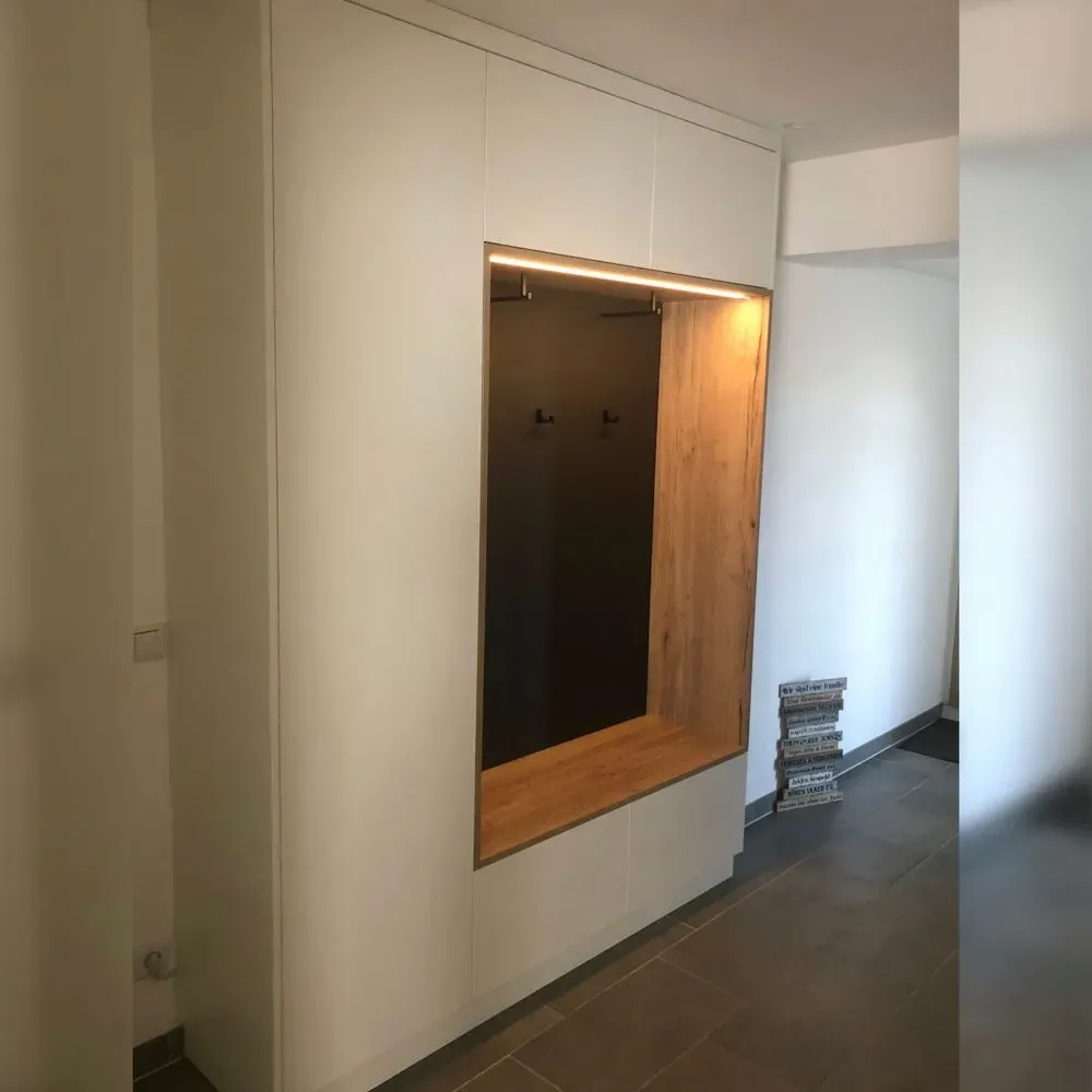 Ein Flur mit einer weißen Wand und einem Holzfenster.