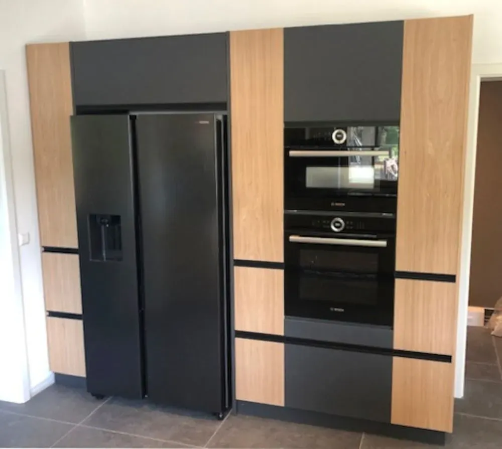 Eine Küche mit schwarzen Geräten und Holzschränken