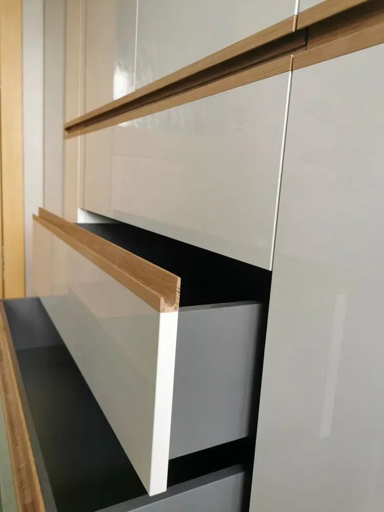 Eine Nahaufnahme einer Schublade in einem Schrank mit einem Holzgriff.