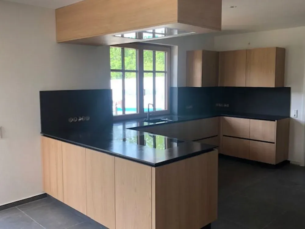 Eine Küche mit Holzschränken und einer schwarzen Arbeitsplatte