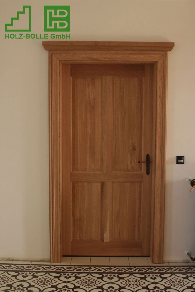 Eine Holztür befindet sich in einem Raum mit gefliestem Boden.