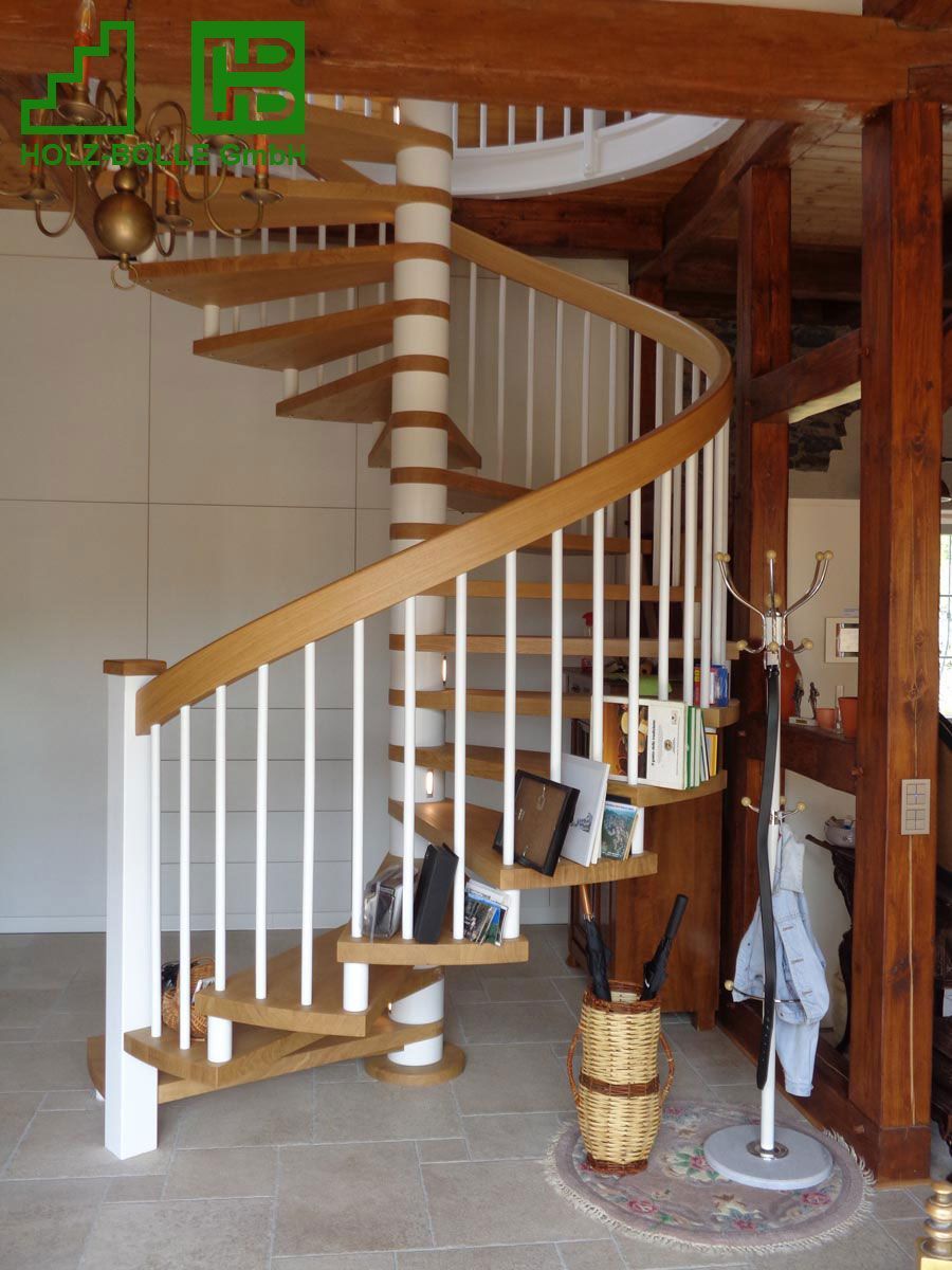 Eine Wendeltreppe mit Holzstufen und weißem Geländer