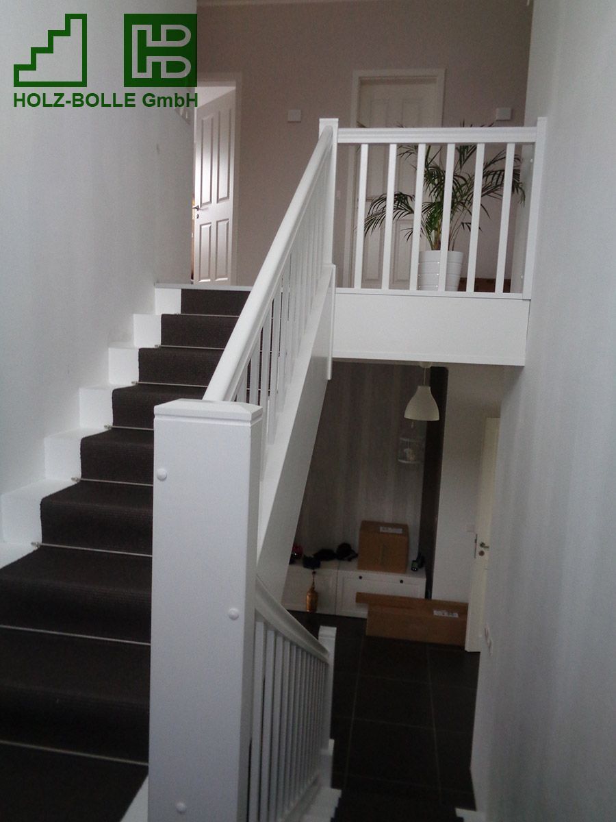 Eine Treppe mit weißem Geländer und einem Schild mit der Aufschrift „Holz-Bolle GmbH“