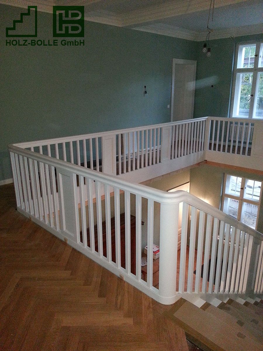 Eine Holztreppe mit einem weißen Geländer in einem Raum.