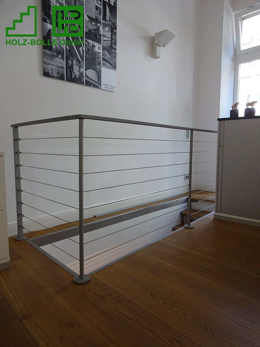 Eine Treppe mit Edelstahlgeländer und Holzstufen.