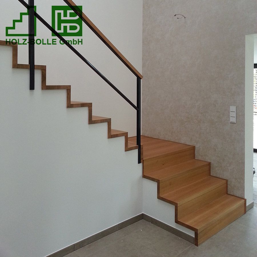 Eine Holztreppe mit einem Metallgeländer und einem Schild mit der Aufschrift „Holz Folle GmbH“