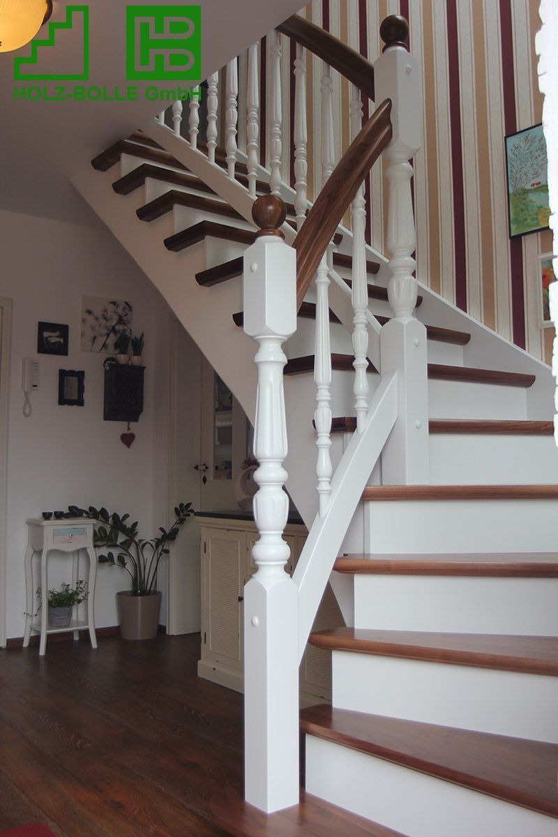 Eine Treppe mit weißem Geländer und Holzstufen