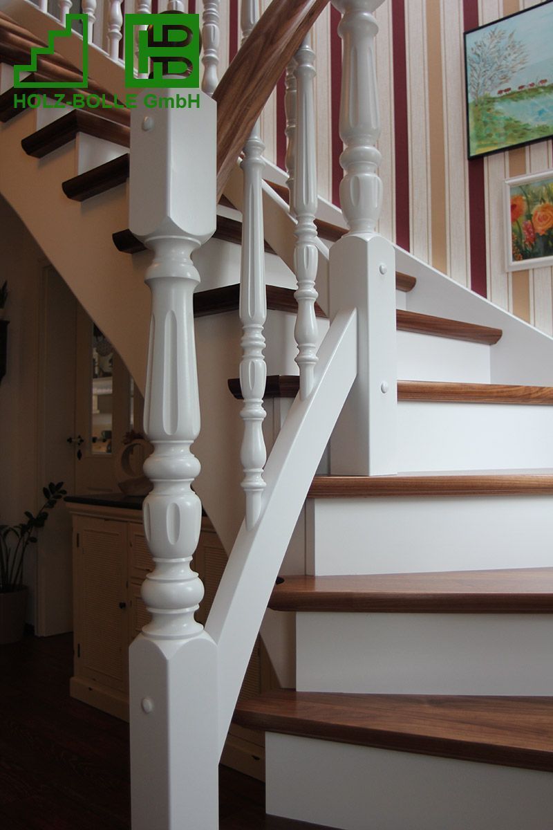 Eine Treppe mit weißem Geländer und Holzstufen