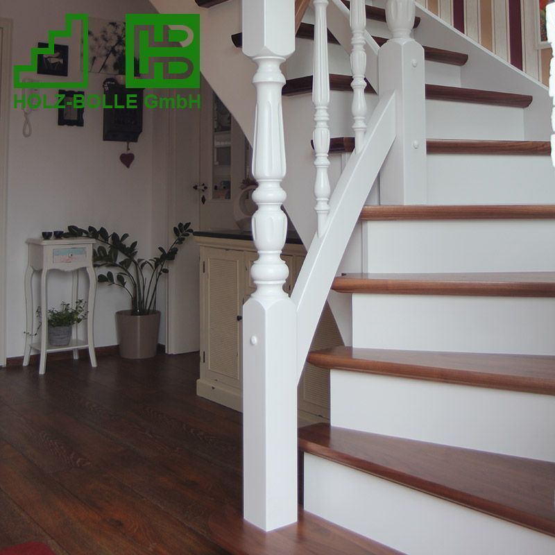 Eine Treppe mit weißem Geländer und Holzstufen