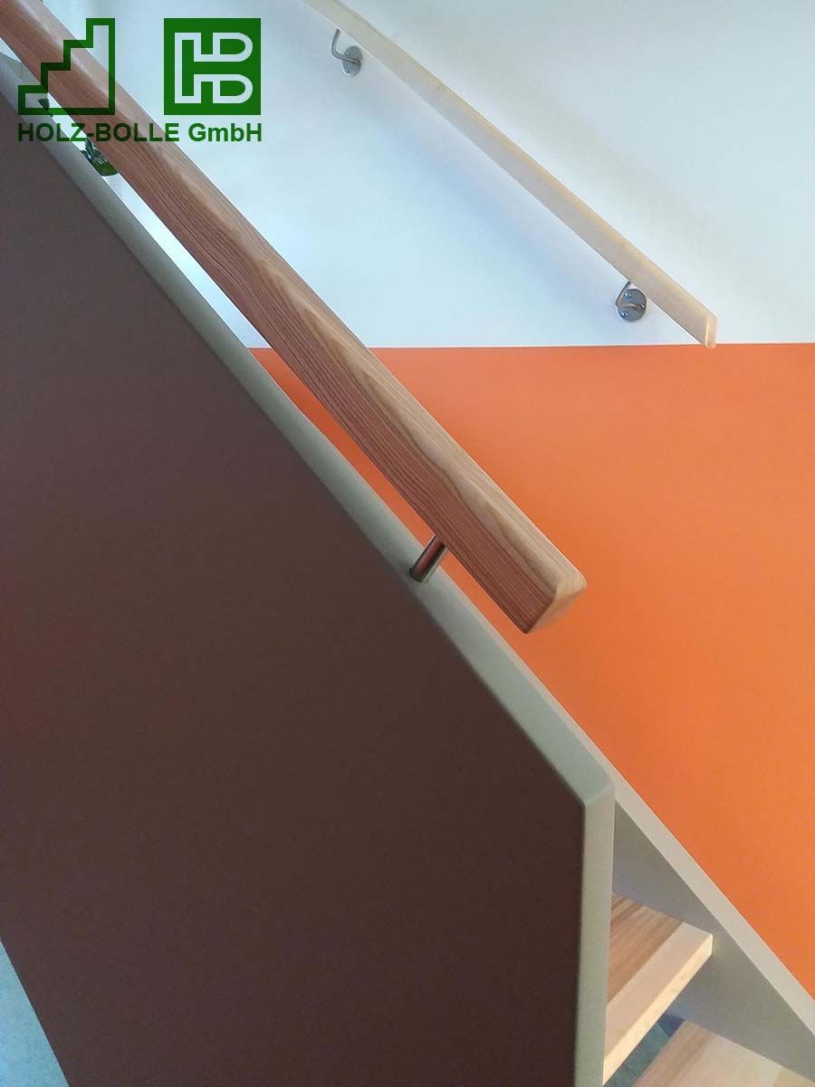 Ein Holzgeländer auf einer Treppe mit dem Buchstaben h darauf