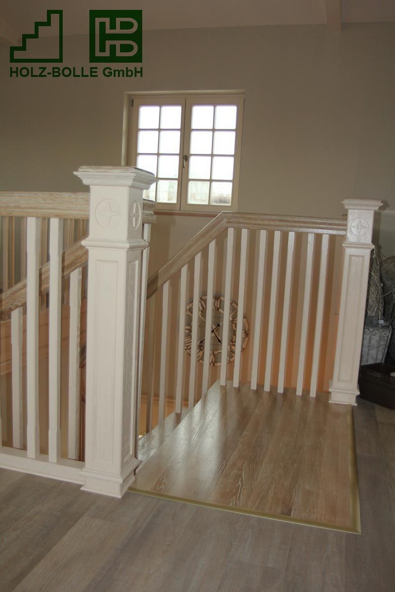 Eine Holztreppe mit weißem Geländer und Fenster