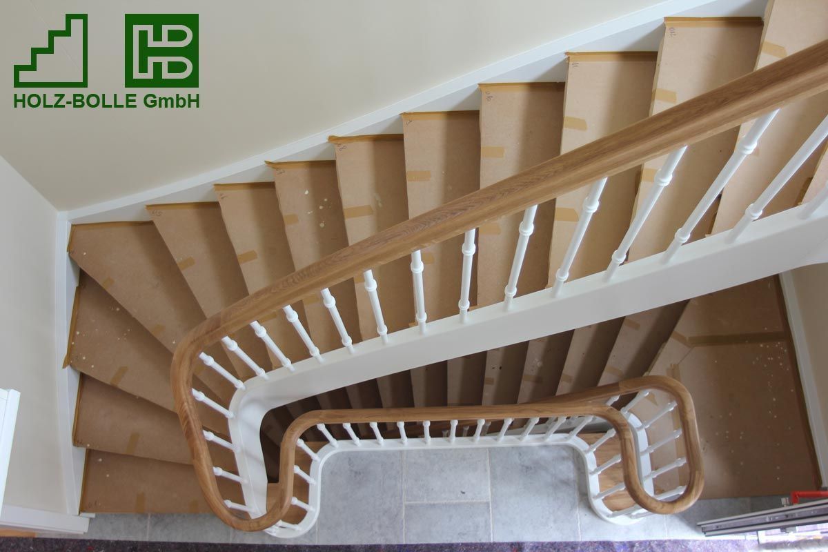 Eine Holztreppe mit weißem Geländer und Logo der Holz-Bolle GmbH