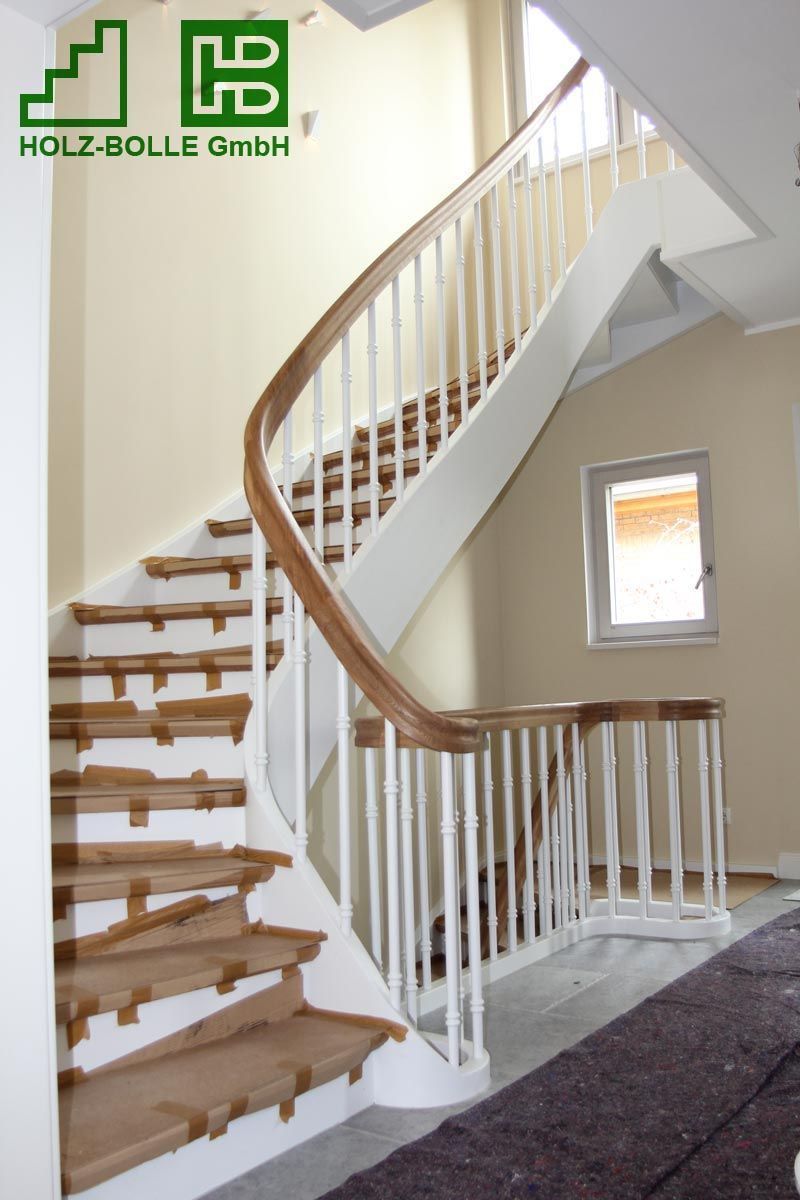 Eine Holztreppe mit weißem Geländer und einem Schild mit der Aufschrift „Holz-Bolle GmbH“