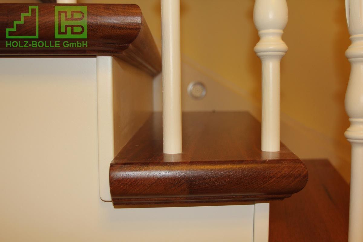 Eine Nahaufnahme einer Holztreppe mit einem weißen Geländer