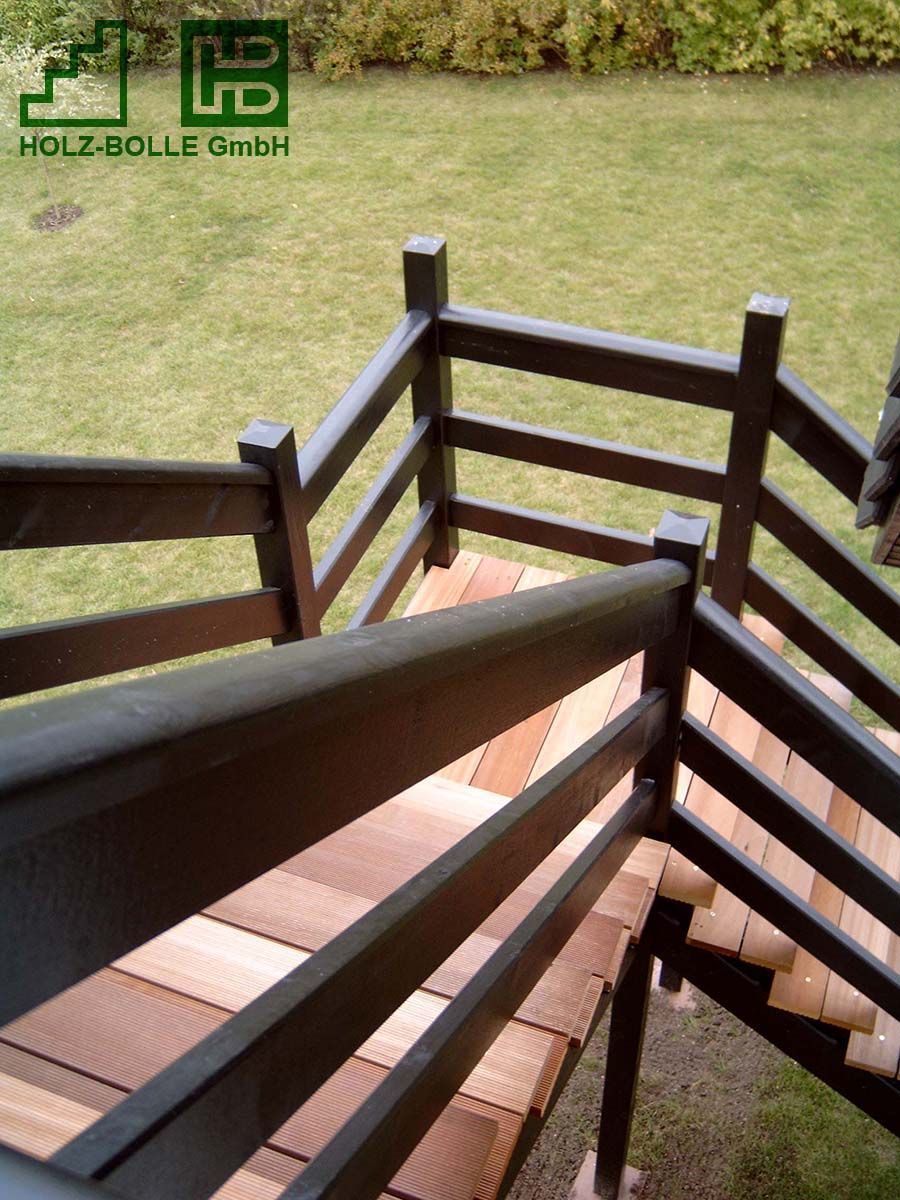 Eine Holztreppe mit Holzgeländer, die zu einer Rasenfläche hinaufführt.