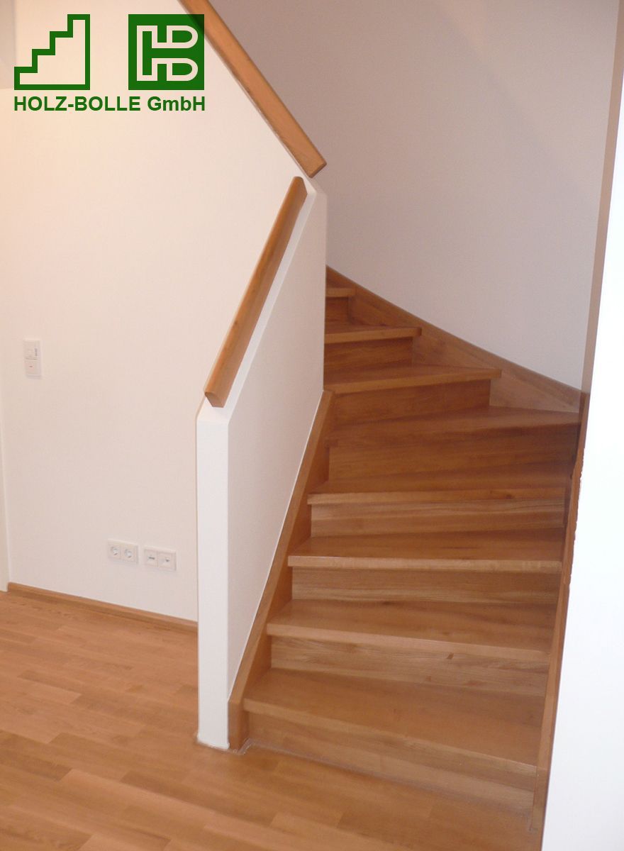 Eine Holztreppe mit einem Holz-Bölle GmbH Logo an der Wand
