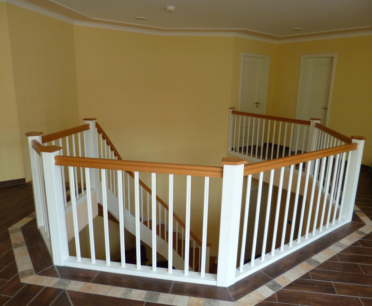 Eine Treppe mit weißem Geländer und Holzhandläufen