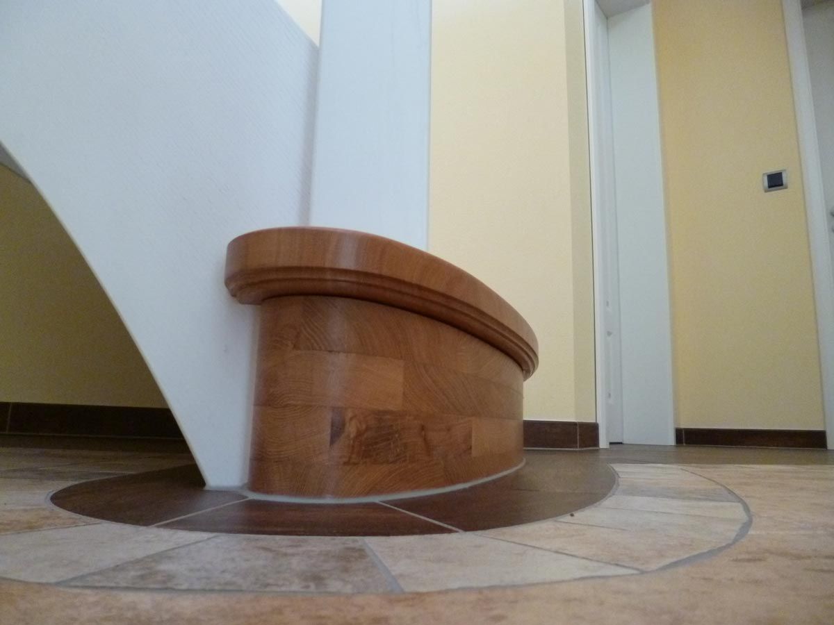 Eine Treppe mit Holzgeländer und Fliesenboden