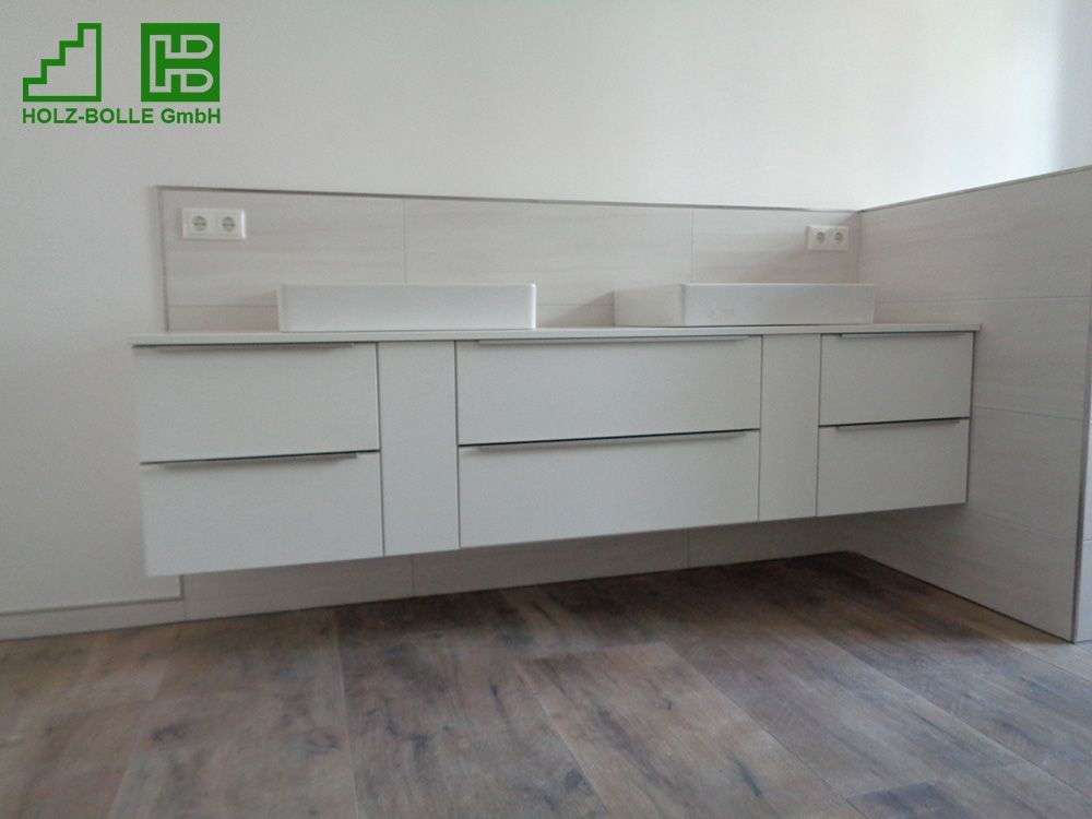 Ein Badezimmer mit zwei Waschbecken und einem Schild mit der Aufschrift „Holz-Bolle GmbH“