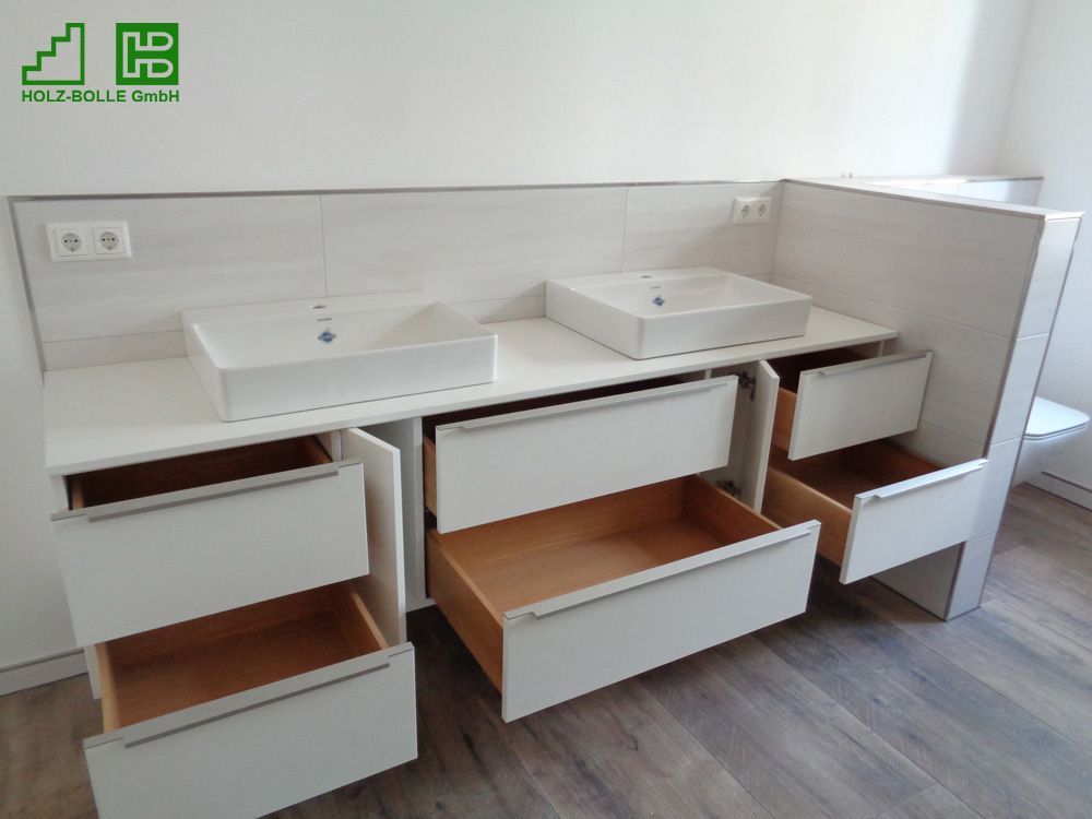 Ein Badezimmer-Waschtisch mit zwei Waschbecken und offenen Schubladen