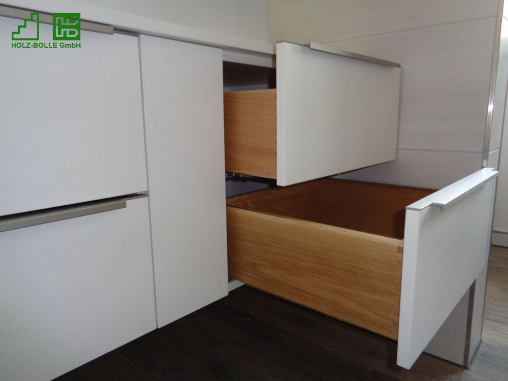 Ein weißer Schrank mit einer Holzschublade darunter