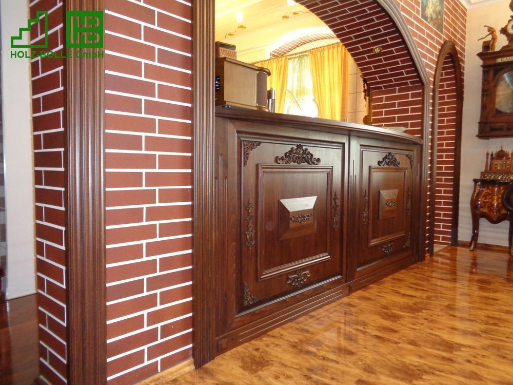 Eine Ziegelwand mit einem Holzschrank davor