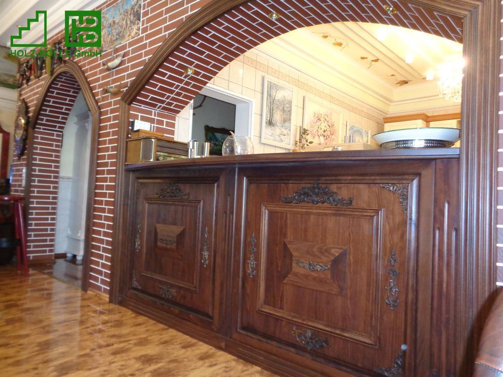 Eine Holztheke in einem Raum mit einer Ziegelwand dahinter.