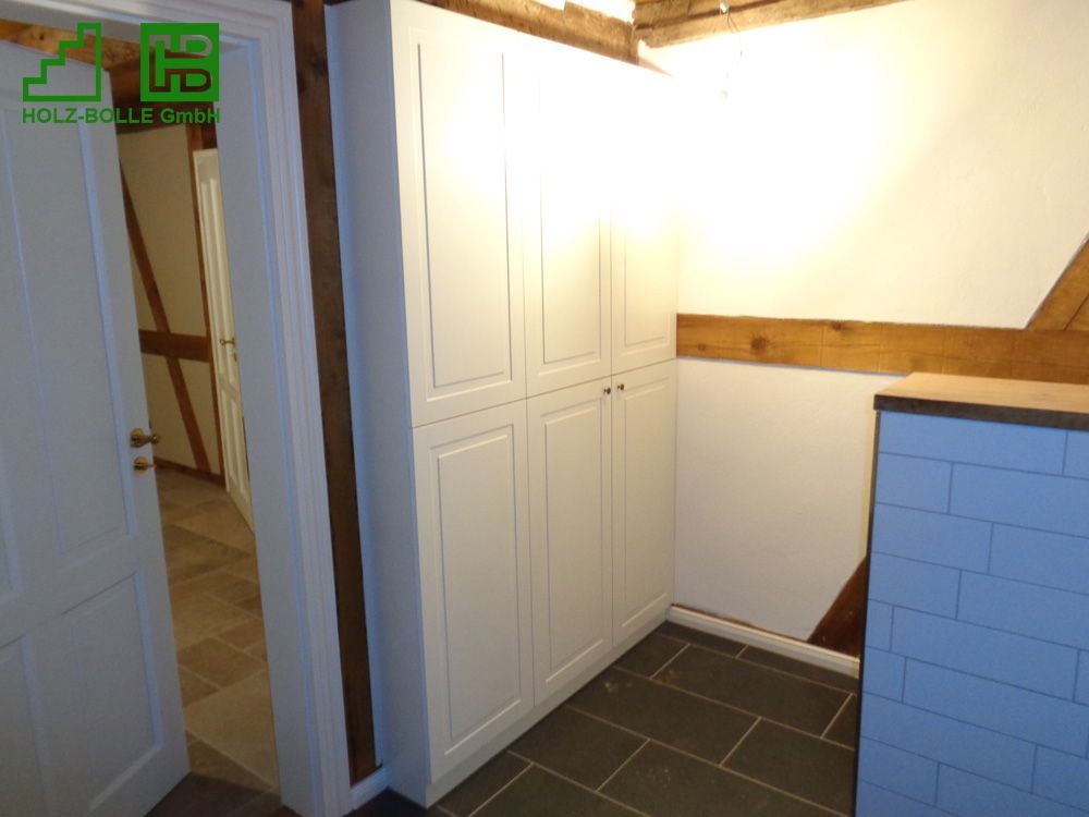 Ein Raum mit weißen Schränken und einer Ziegelwand