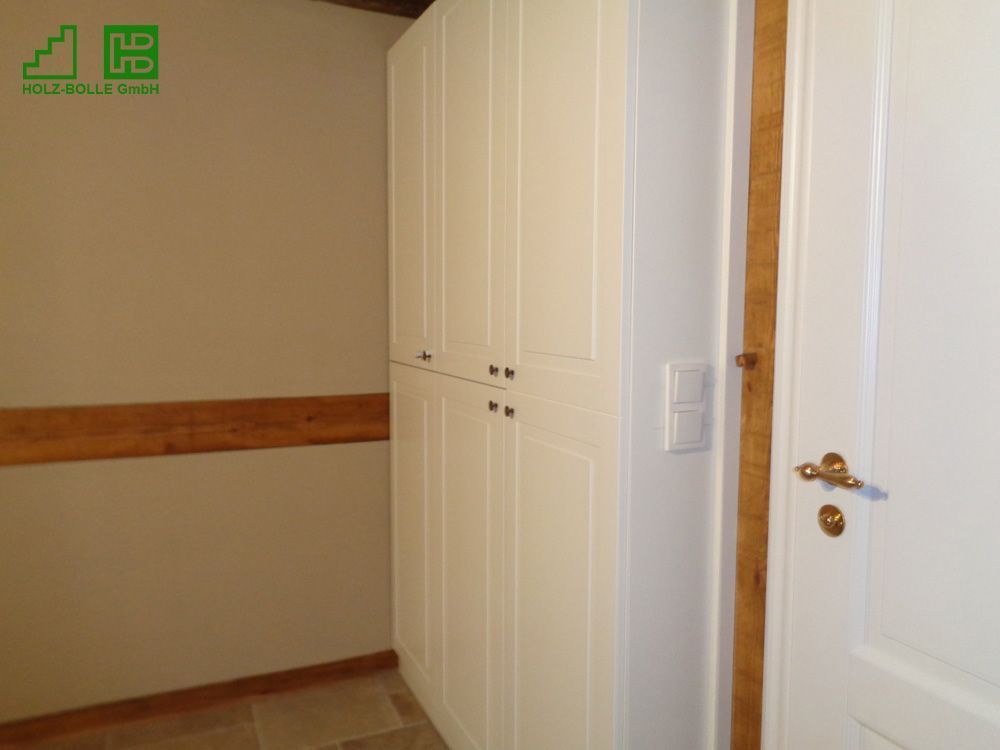 Ein Zimmer mit weißen Schränken und einer weißen Tür