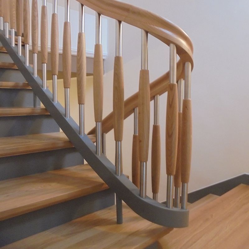 Eine Treppe mit geschwungenem Geländer aus Holz und Metall