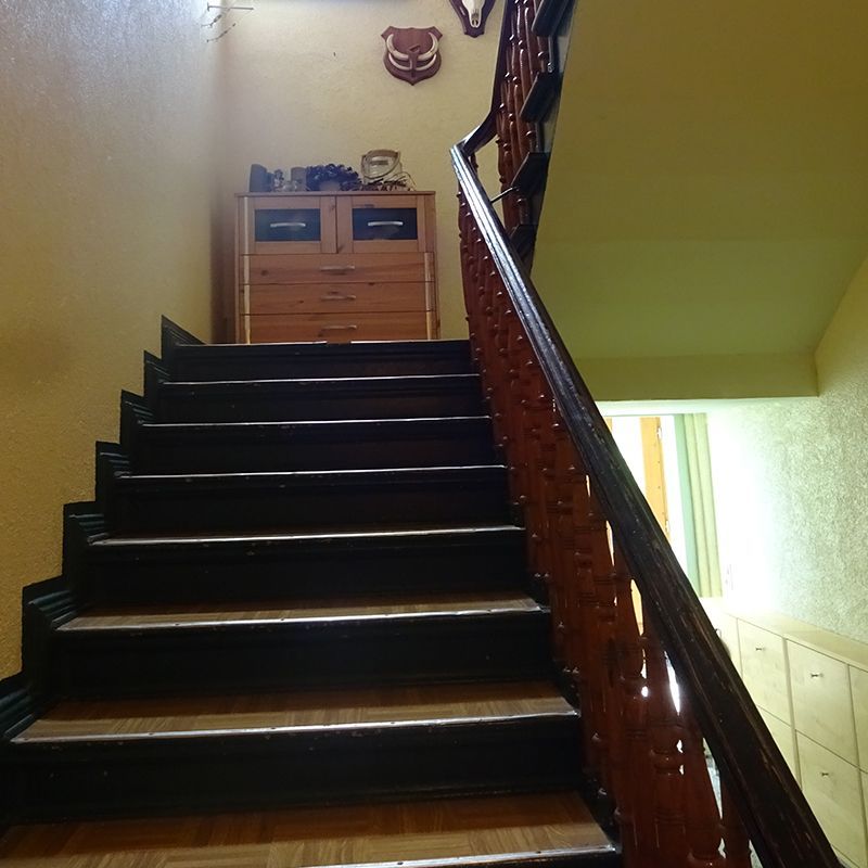 Eine Holztreppe mit einem Hirschkopf an der Wand