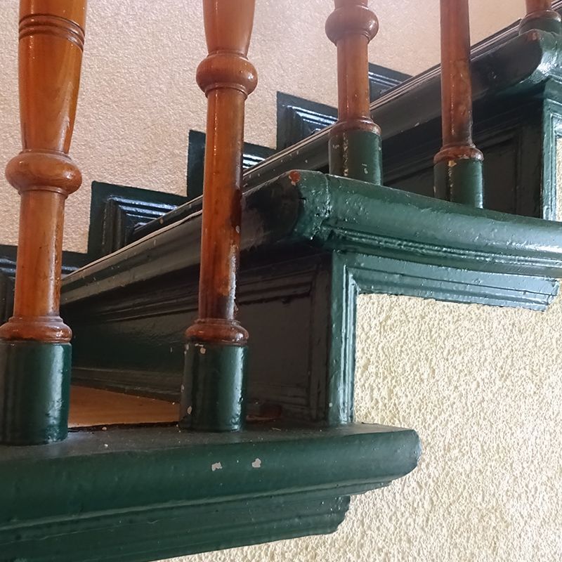 Eine Nahaufnahme von einem Holzgeländer auf einer Treppe