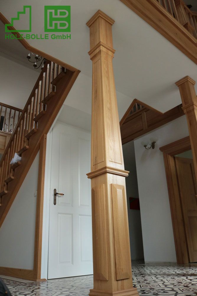 Eine Holzsäule in einem Flur neben einer Treppe